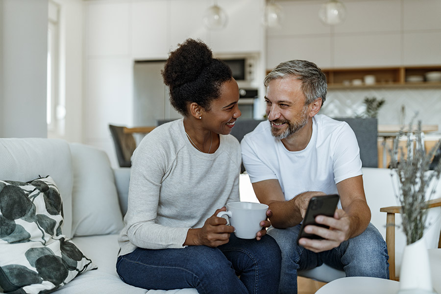 Couple on couch cuddling on morning and laughing