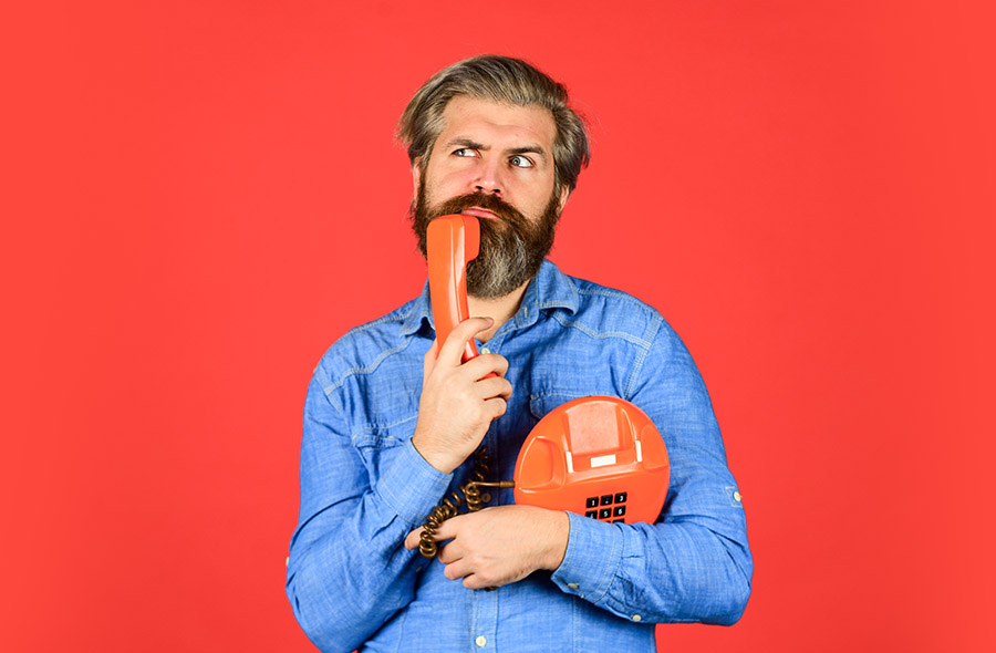 Man on red background funny face holding phone