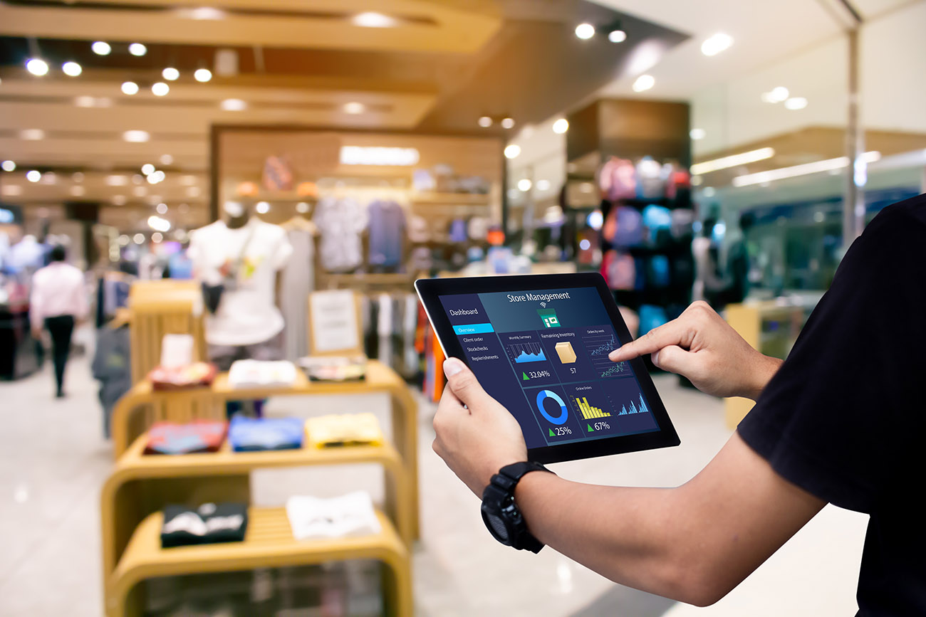 Manager using tablet automation software while managing clothing store