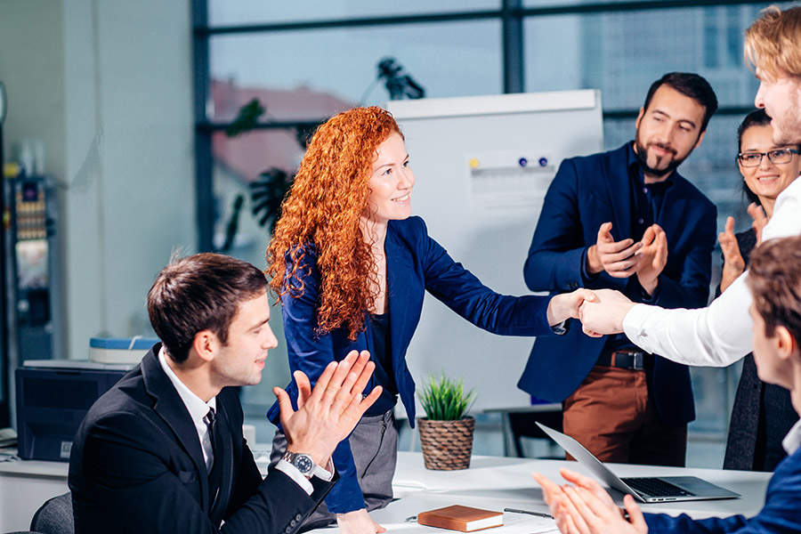 Red head sales woman pitching to executives