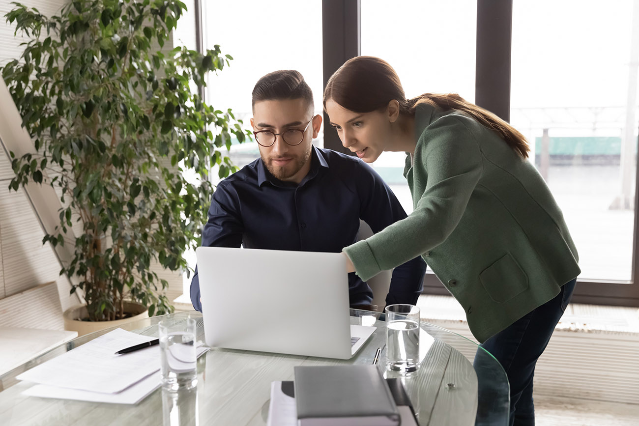 Team of two professionals working on computer deciding next software