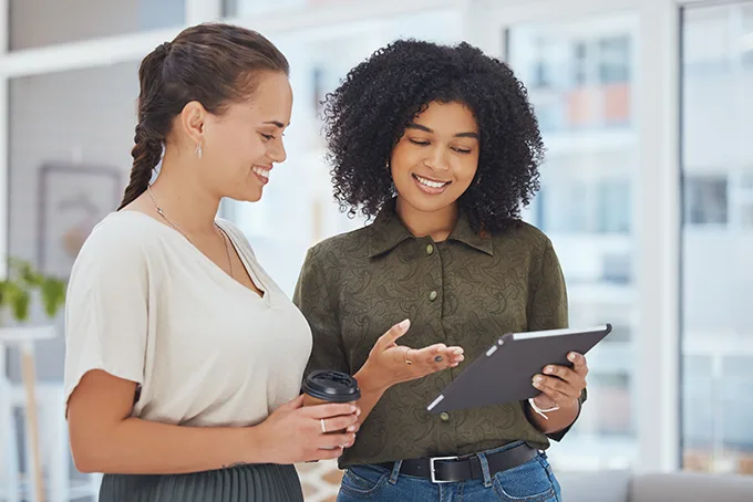 Two women coworkers working together on technology