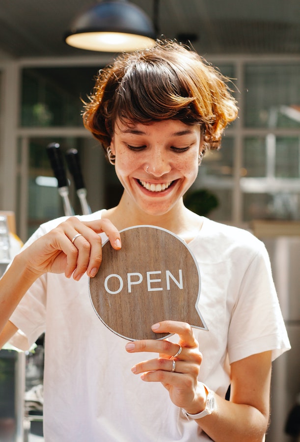 woman-holding-open-sign-in-workplace