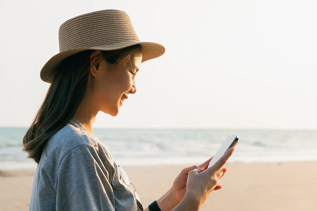 woman-using-phone-at-beach