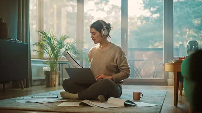 Woman working from home sitting on ground reading papers