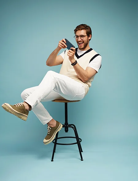 excited man using iphone on bar stool