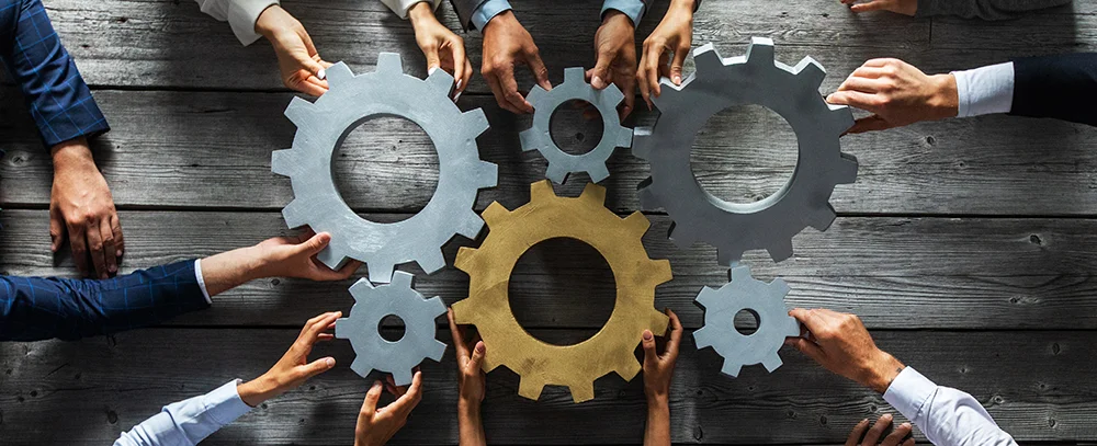 A diverse team of professionals collaborating around a table in a modern office setting while discussing sales strategies and scheduling plans